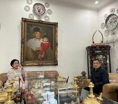 Namun selain keduanya berbincang, ada hal menarik lainnya yang menjadi sorotan. Figura foto yang memperlihatkan sosok Bung Karno tengah memangku Megawati saat masih kecil, bikin gagal fokus.<br>