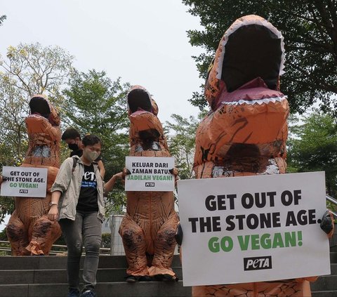 Sejumlah aktivis People for the Ethical Treatment of Animals (PETA) memakai kostum dinosaurus saat menggelar aksi di kawasan Dukuh Atas, Jakarta, Selasa (24/10/2023). 
