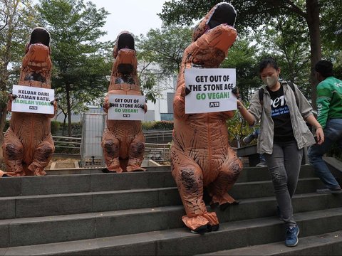 FOTO: Berkostum Dinosaurus, Aktivis PETA Ajak Masyarakat Hidup Vegan Tanpa Eksploitasi Hewan