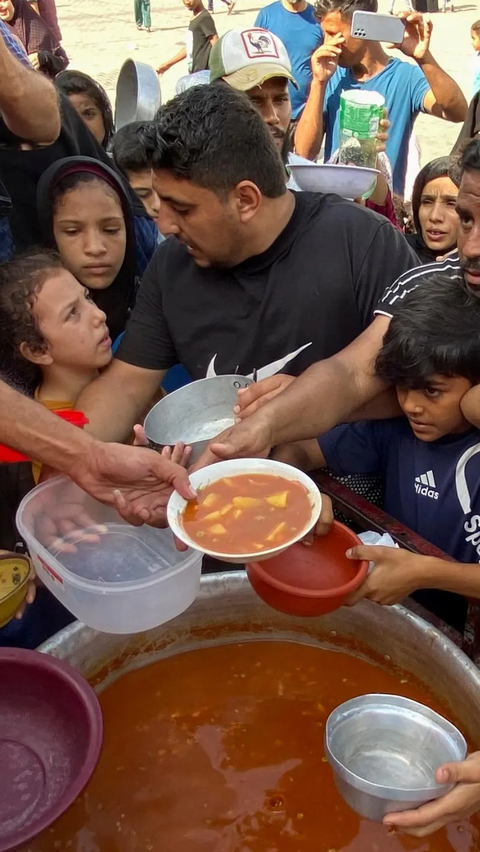 Antrean warga Palestina saat berebut makanan di kamp pengungsian Rafah, Jalur Gaza Selatan.<br>