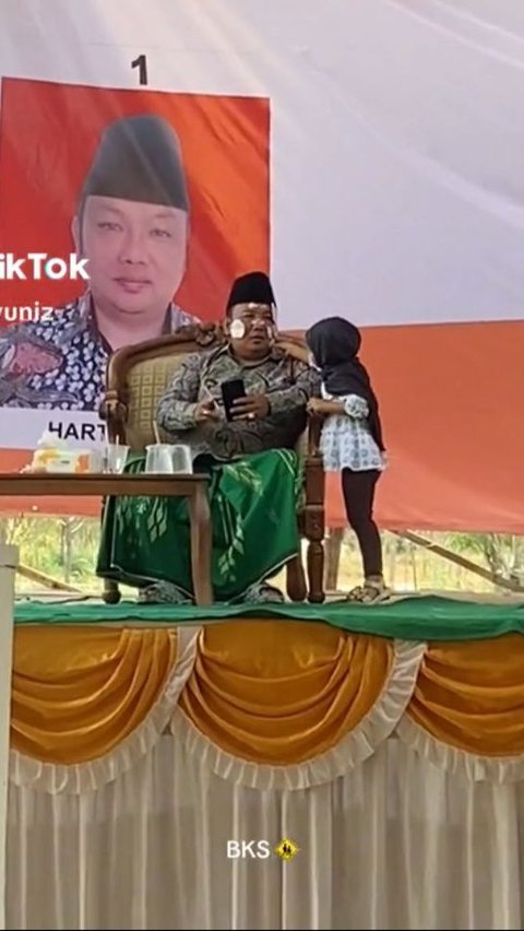 Pilkades di Madura Ini Kelewat Santai, Calon Kepala Desa Asyik Mainan Stiker dengan Anak Kecil di Atas Panggung<br>