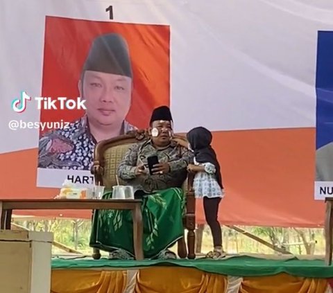 Pilkades di Madura Ini Kelewat Santai, Calon Kepala Desa Asyik Mainan Stiker dengan Anak Kecil di Atas Panggung