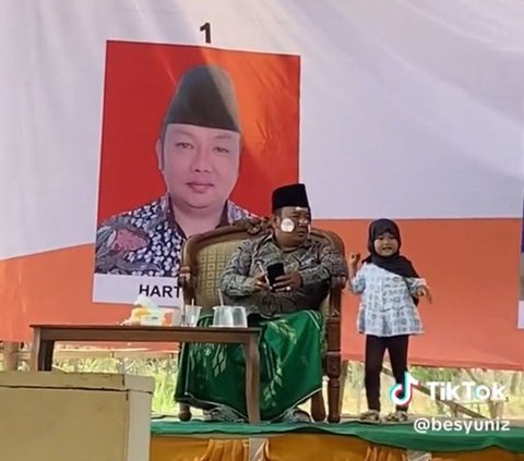 Pilkades di Madura Ini Kelewat Santai, Calon Kepala Desa Asyik Mainan Stiker dengan Anak Kecil di Atas Panggung