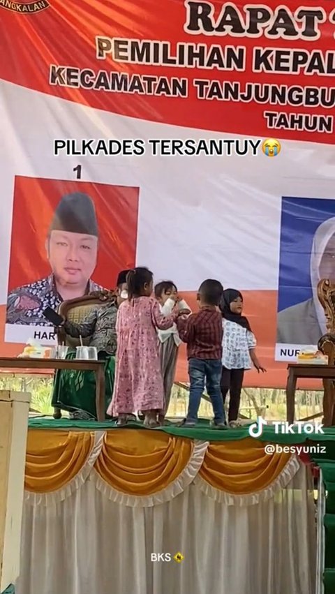 Pilkades di Madura Ini Kelewat Santai, Calon Kepala Desa Asyik Mainan Stiker dengan Anak Kecil di Atas Panggung