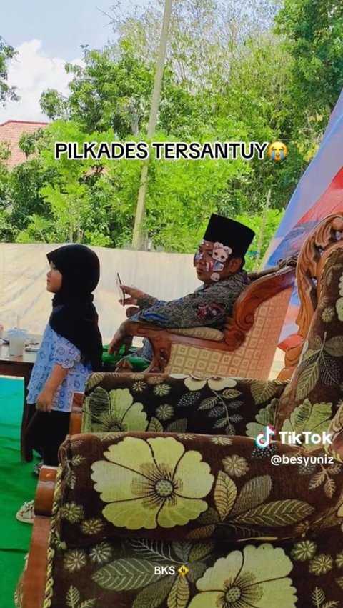 Pilkades di Madura Ini Kelewat Santai, Calon Kepala Desa Asyik Mainan Stiker dengan Anak Kecil di Atas Panggung