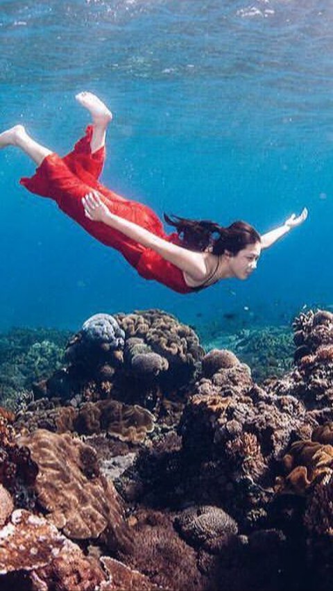 While diving, Karen is seen wearing a beautiful red dress.