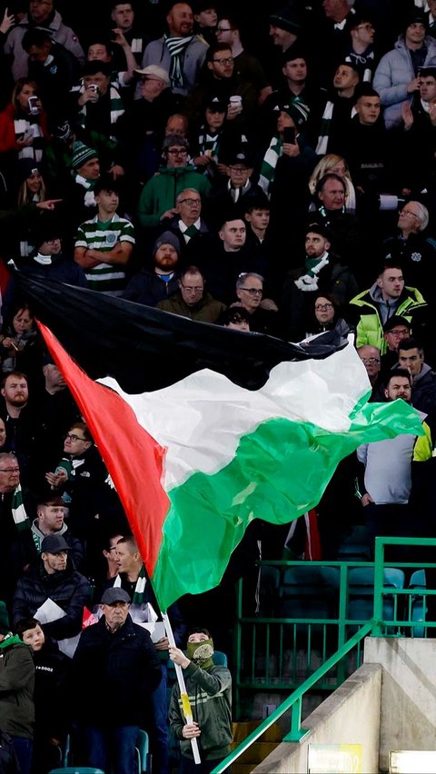 Para suporter yang memadati Stadion Celtic Park ini beramai-ramai mengibarkan bendera Palestina.
