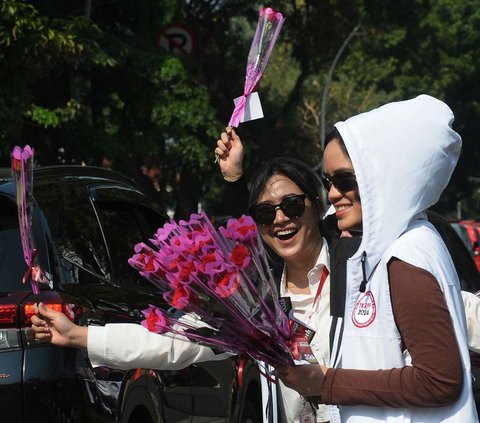 Sejumlah relawan bakal calon presiden Ganjar Pranowo tampak membagikan bunga mawar kepada para pengendara di Jalan Raya Diponegoro, Jakarta, Sabtu (28/10/2023). Aksi ini dilakukan untuk merayakan ulang tahun ke-55 Ganjar Pranowo.