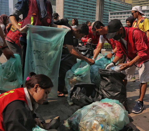 Sejumlah pegiat peduli lingkungan  mengumpulkan sampah yang berserakan di kawasan Bundaran HI, Jakarta, Minggu (29/10/2023).