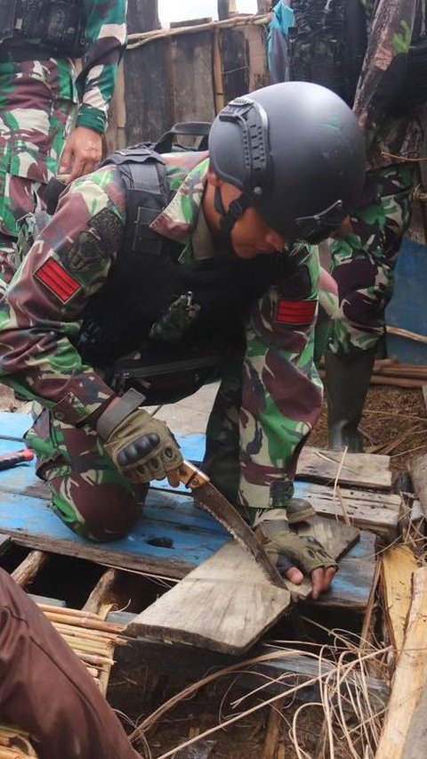 Momen saat prajurit TNI membantu warga membangun rumah adat yang akan digunakan sebagai tempat tinggal.<br>