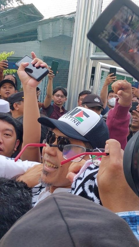 Penampakan Munarman Bebas dari Penjara, Pakai Topi Palestina dan Senyum Lebar<br>