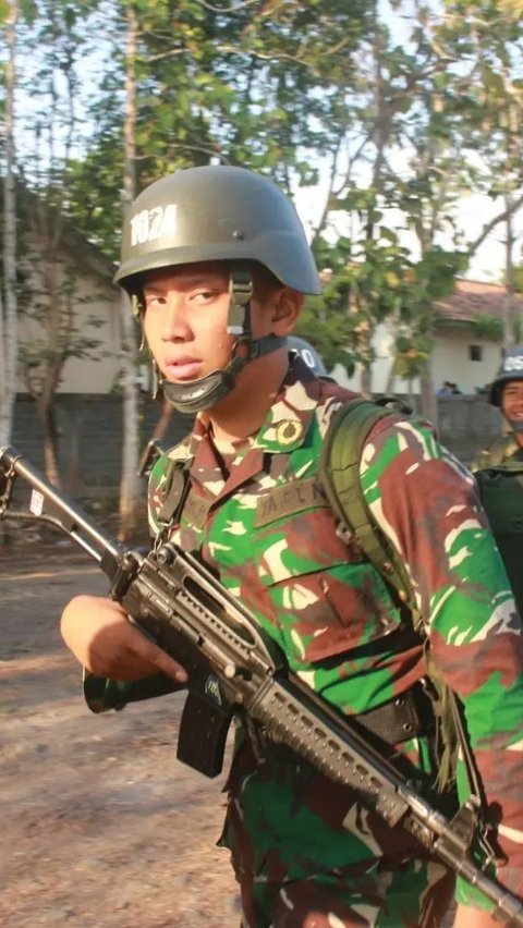 He appeared to be wearing the typical TNI camouflage uniform while carrying a long-barreled rifle.