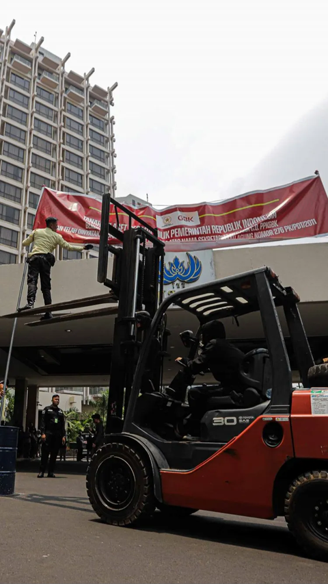 Pemasangan spanduk tersebut dilakukan dengan bantuan kendaraan forklift.