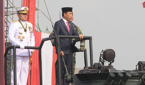 Berdasarkan pantauan di Monas, Jokowi mengenakan peci dan jas hitam. Mantan Gubernur DKI Jakarta itu berdiri tank BMP-3F Korps Marinir.<br>
