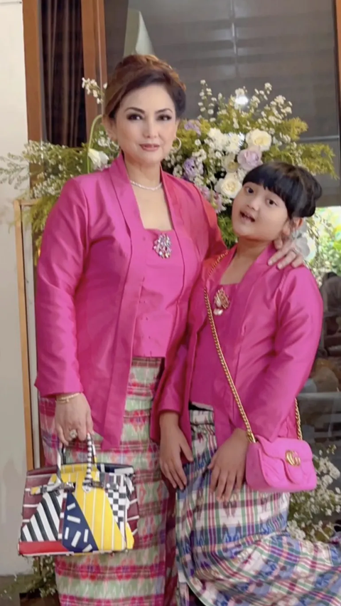 Grandmother and granddaughter are very compact wearing pink kebaya.