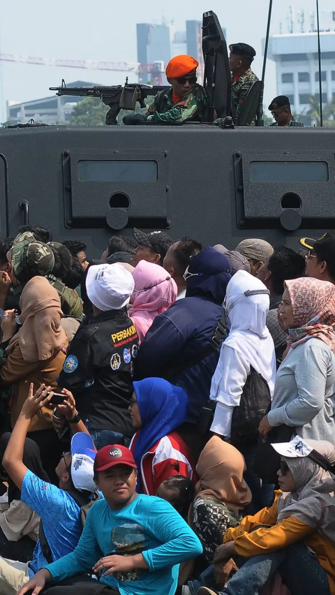 Tampak masyarakat yang antusias saat menyaksikan atraksi terjun payung pada peringatan HUT ke-78 TNI di Lapangan Silang Monumen Nasional (Monas).