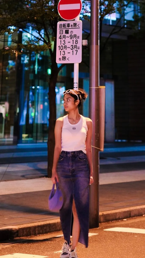 Wearing a white sleeveless and jeans skirt.