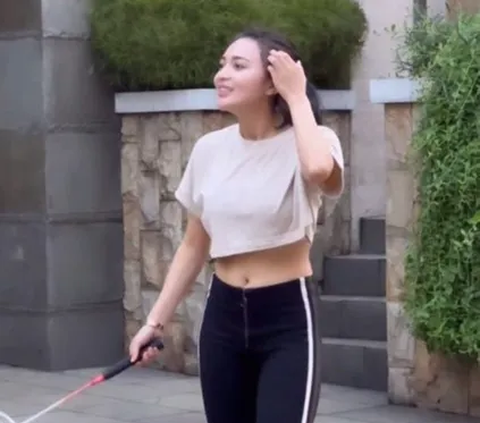 Wika wears a crop top that makes her stomach visible.
