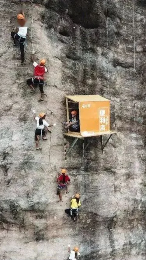 The closest sight of a food stall attached to a cliff:   Calm Seller Serves Hikers in Urgent Need of Snacks.