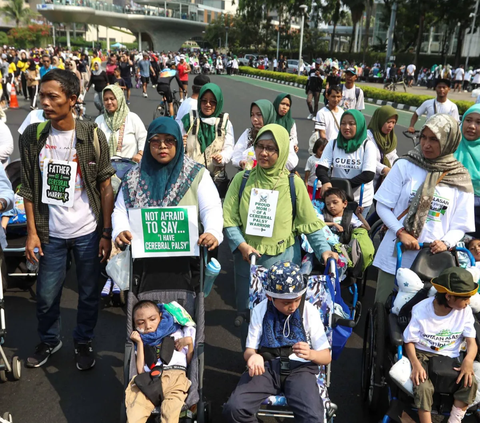 Orang tua mendampingi anak-anak pengidap Celebral Palsy mengikuti kampanye peringatan Hari Celebral Palsy dunia saat Hari Bebas Kendaraan Bermotor (HBKB) di Kawasan Thamrin, Jakarta, Minggu (8/10/2023).