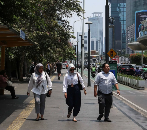 Pekerja berjalan di trotoar di kawasan Jakarta saat fenomena Kulminasi Utama atau Hari Tanpa Bayangan pada Senin (9/10/2023) siang.