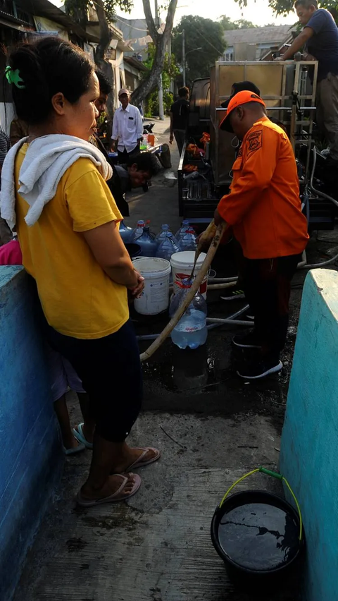 Petugas BPBD Tangerang Selatan saat melayani warga yang mengantre mengisi air bersih.