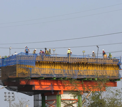 Pekerja menyelesaikan proyek pembangunan jalan tol layang (Elevated) Ancol Timur-Pluit (Harbour Road II) di Jalan RE. Martadinata, Tanjung Priok,  Jakarta Utara,  Senin (9/10/2023).