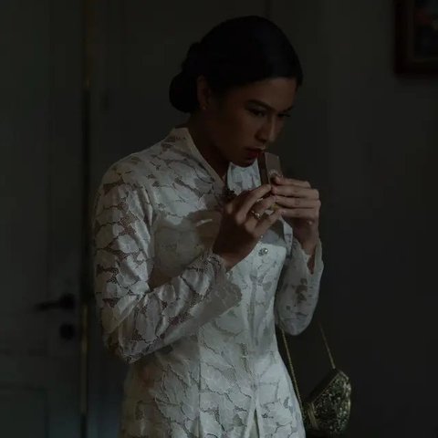 Dian Sastro tampil memesona dengan kebaya putih yang memikat, lengkap dengan detail leher yang unik.