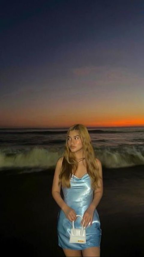 Vacation at the beach, Victoria wears a satin mini dress.