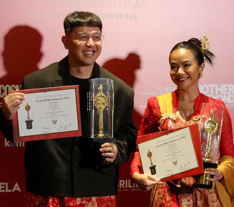 Penyanyi Yura Yunita (kanan) bersama Donne Maulana  berpose memegang piala saat menerima Anugerah Festival Film Indonesia (FFI) 2023 kategori Pencipta Lagu Tema Terbaik  di Ciputra Artpreneur, Jakarta, Selasa (14/11/2023).