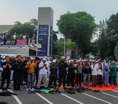 Massa demonstran juga melakukan aksi salat berjemaah di tengah Jalan Asia-Afrika selama menggelar aksi demo menolak konser Coldplay.