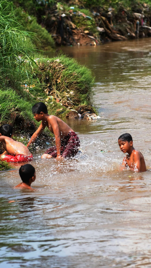 FOTO: Wajah Asli Ciliwung Setelah Sebelumnya Nyaris Kerontang Akibat Kemarau, Kini Kembali Jadi Tempat Berenang Anak-Anak
