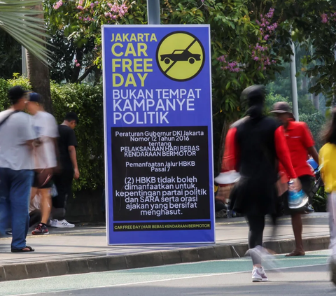 FOTO: Banner Larangan Kampanye Politik Mencuri Perhatian Saat Car Free Day di Kawasan Thamrin