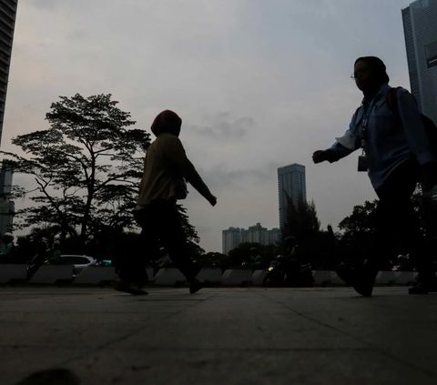 Aktivitas pekerja saat melintasi trotoar di kawasan Jalan Jenderal Sudirman, Jakarta, Selasa (21/11/2023)  Pemrov DKI Jakarta resmi menetapkan kenaikan Upah Minimum Provinsi (UMP) DKI Jakarta.<br>