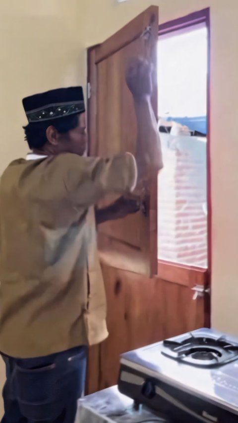 Pak Nasir tampak mencoba pintu belakang di ruang dapurnya yang langsung mengarah ke rumah tetangganya.