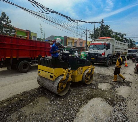 Petugas melakukan penambalan pada jalan berlubang di Jalan Moh. Toha, Parung Panjang, Kabupaten Bogor, Jawa Barat, Rabu (22/11/2023). Sudah bertahun-tahun, jalan raya yang kerap dilalui truk-truk tambang itu mengalami kerusakan parah.