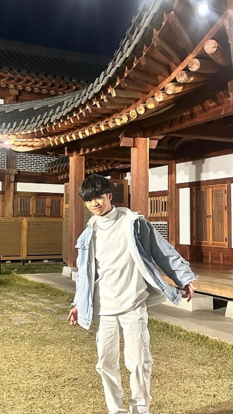 Afan menikmati momen saat berada di Korea Selatan. Ia tampak memakai jaket warna abu.