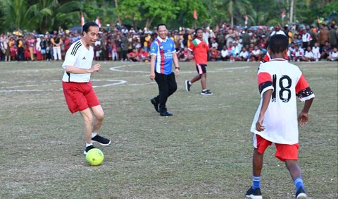 Jokowi yang mengenakan kaus berwarna putih dengan nomor punggung 23 tampak antusias bermain sepak bola bersama para pelajar.<br>