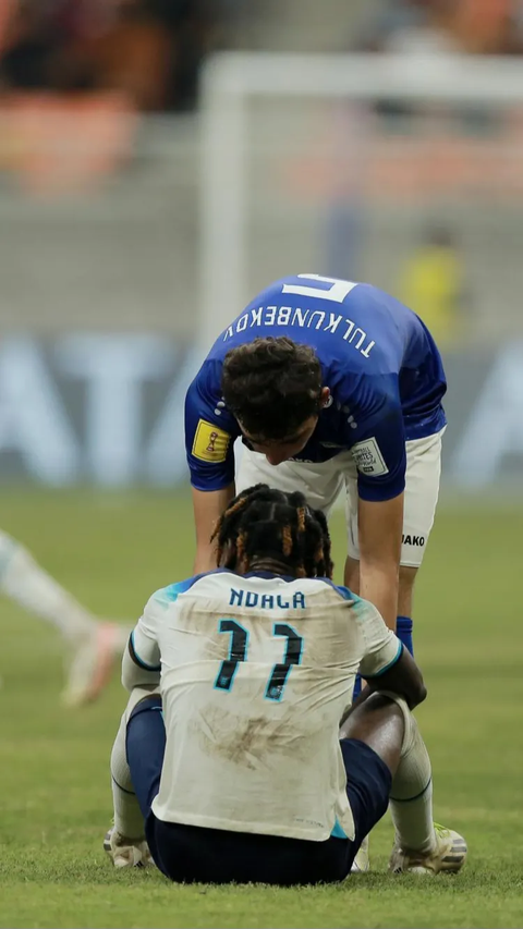 Pemain Uzbekistan U-17, Azizbek Tulkunbekov, berusaha menguatkan pemain Inggris U-17, Joel Ndala, yang kecewa setelah kalah pada babak 16 besar Piala Dunia U-17 2023.