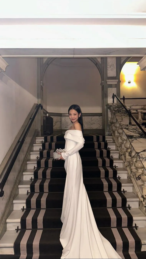 Jennie memilih gaya kontras dengan busana putih yang manis, menampilkan gaun berlengan panjang yang sederhana namun elegan.