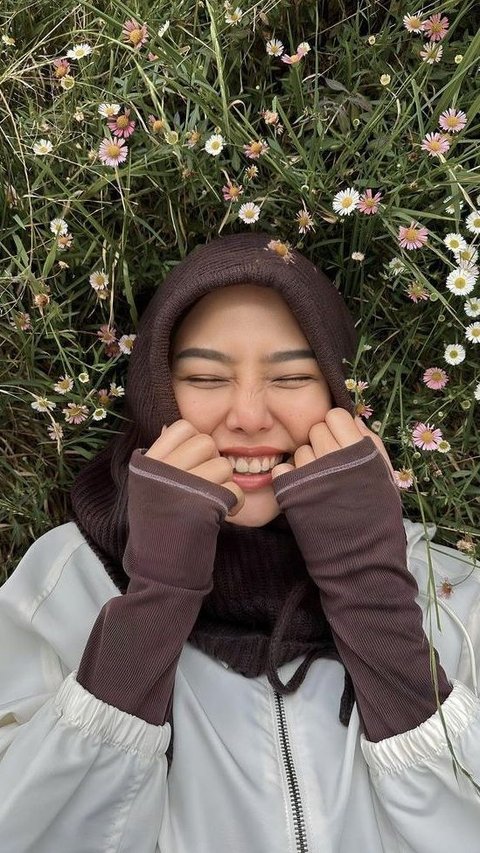 Dara sempat berpose di atas rumput dengan bunga yang baru mekar