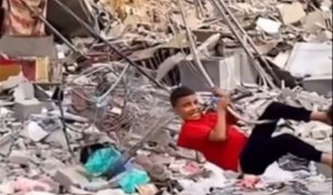 Anak-anak kecil pada video tampak asyik bermain di tengah reruntuhan bangunan.