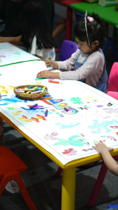 Seorang anak tampak antusias mengikuti kegiatan menggambar dan mewarnai yang tersedia di Joyland Festival 2023.<br>