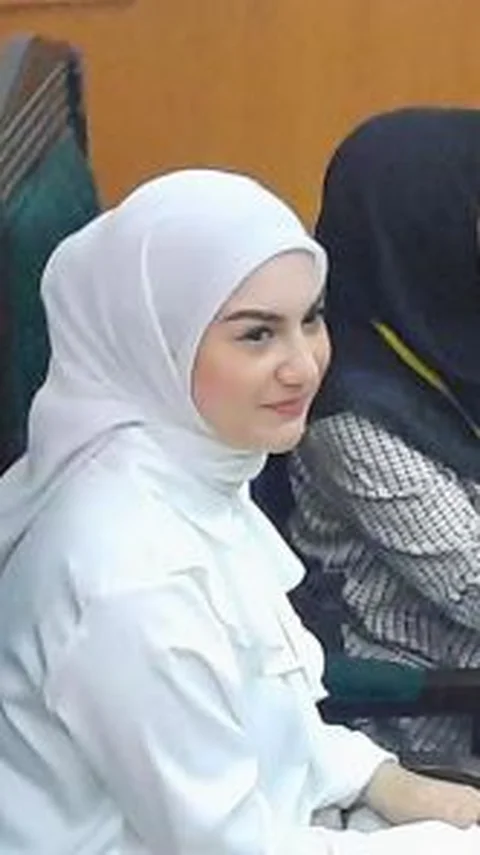 Irish mengenakan hijab segi empat warna putih polos yang diikat simpul di leher.