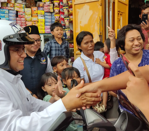 Sambil Bonceng Istri, Anies Baswedan Sapa Warga di Tanah Merah Naik Motor