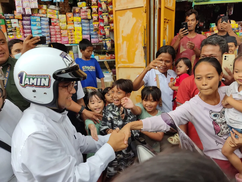 Sambil Bonceng Istri, Anies Baswedan Sapa Warga di Tanah Merah Naik Motor