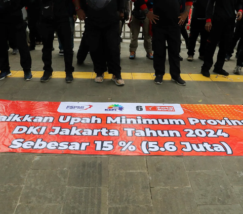 Massa demonstran membentang spanduk kenaikan upah saat menggelar aksi unjuk rasa di depan Balai Kota DKI Jakarta, Selasa (28/11/2023)