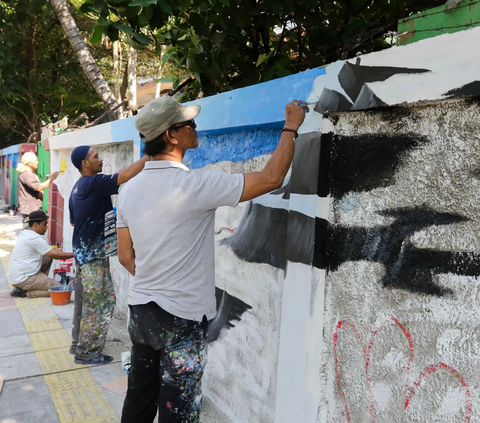 Sejumlah seniman menuangkan ide-ide kreativitasnya pada dinding di pinggir sebuah trotoar jalan di kawasan Cideng, Jakarta, Rabu (29/11/2023). <br>