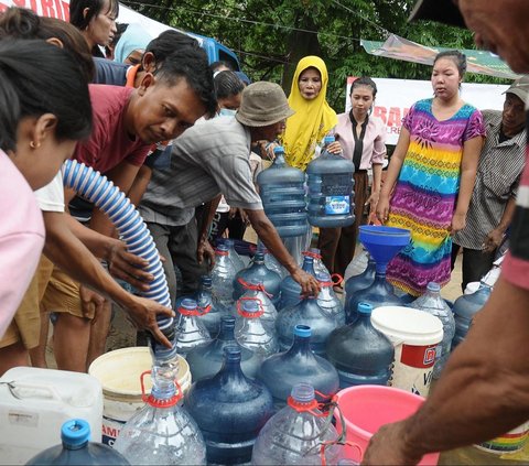 FOTO: Antusiasme Warga Pinggiran Kali Ciliwung Serbu Bantuan Air Bersih