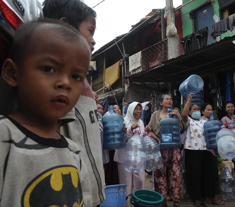 FOTO: Antusiasme Warga Pinggiran Kali Ciliwung Serbu Bantuan Air Bersih